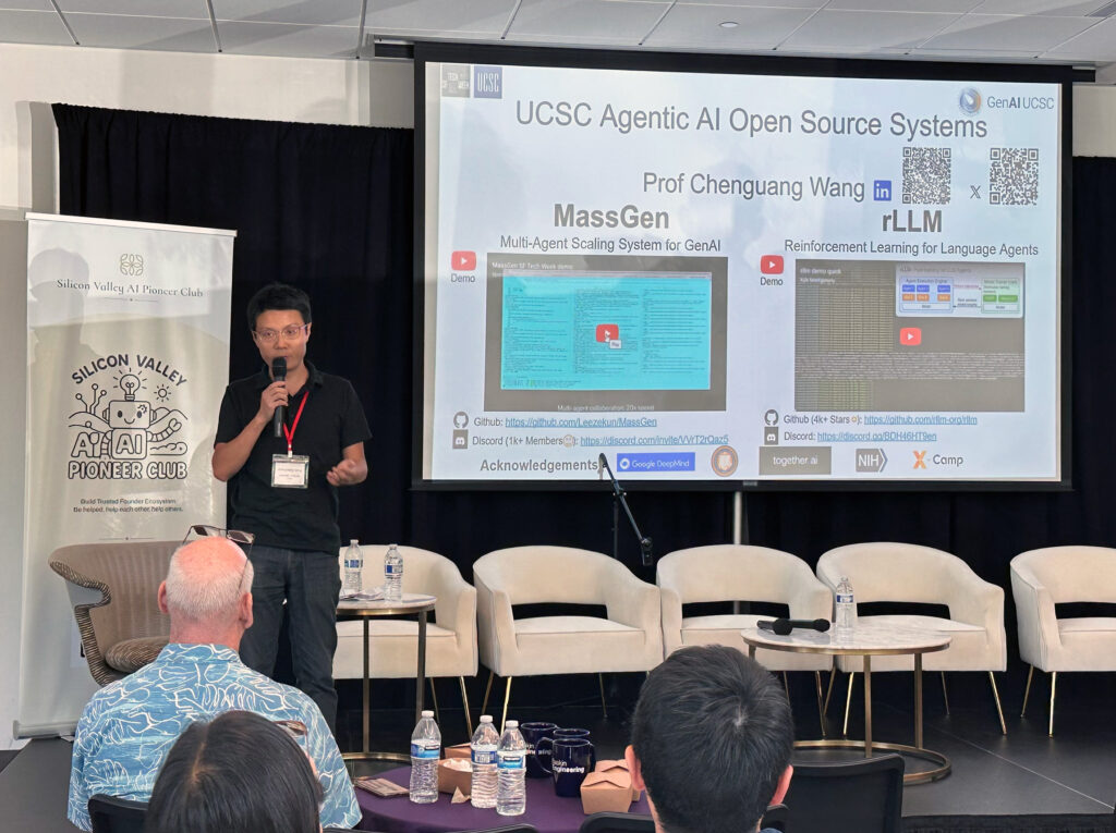Chenguang Wang stands on a stage with a mic and a visual description of his research behind him.