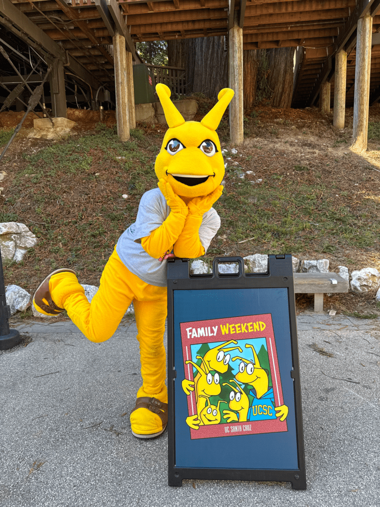 Sammy Slug poses with a Family Weekend sign