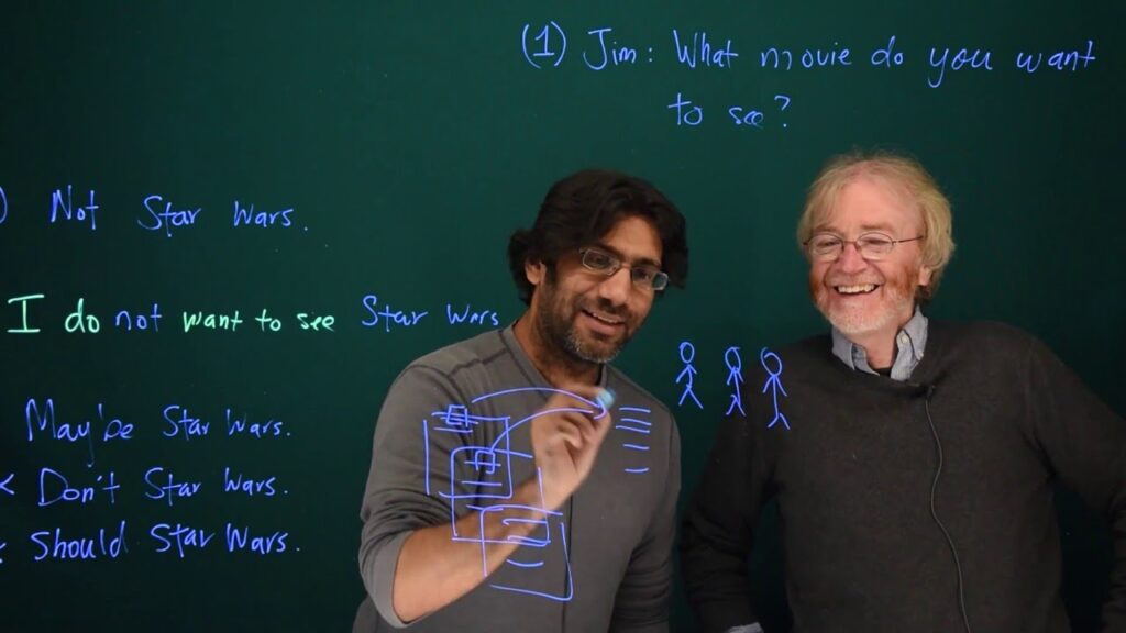 Photo of two linguistics professors writing on glass