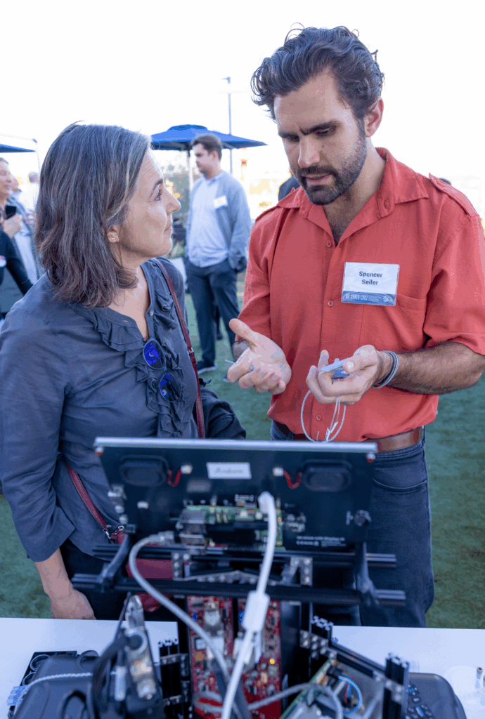 A member of the Braingeneers discusses his new startup venture with a guest