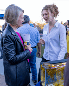 Two women talk at the mixer
