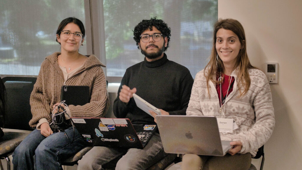 Three students smile at the camera