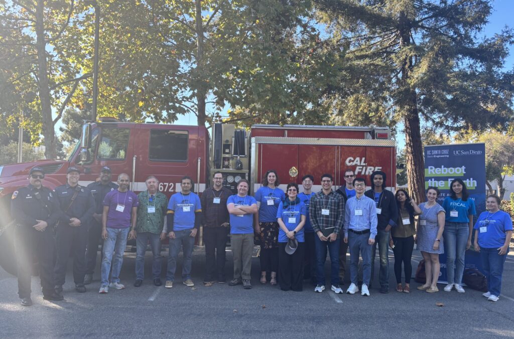 A group of mentors and judges stand in front of a CAL FIRE fire engine.