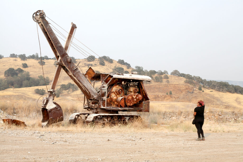 Student studies a rusted excavator in California.