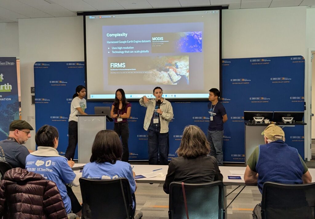 Four students present at the event in front of a panel of judges