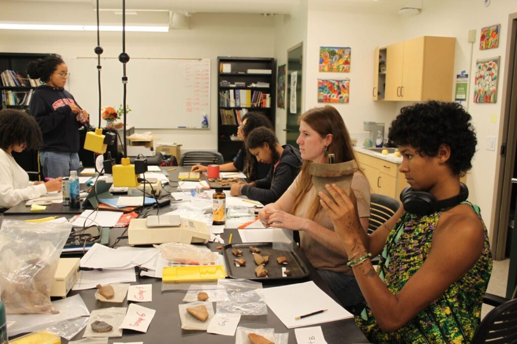 students in lab setting measuring pottery shards