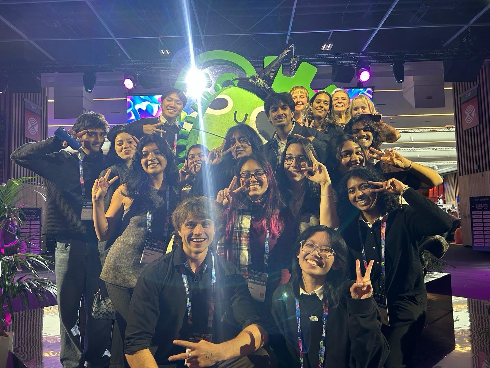 A group of students pose smiling, indoors at the 2025 iGEM jamboree event