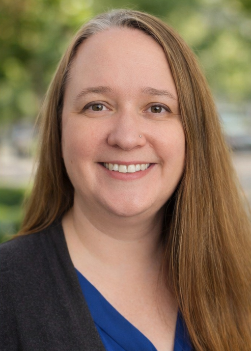 Erica Simpkins, business systems analyst, in a blue shirt and black jacket.