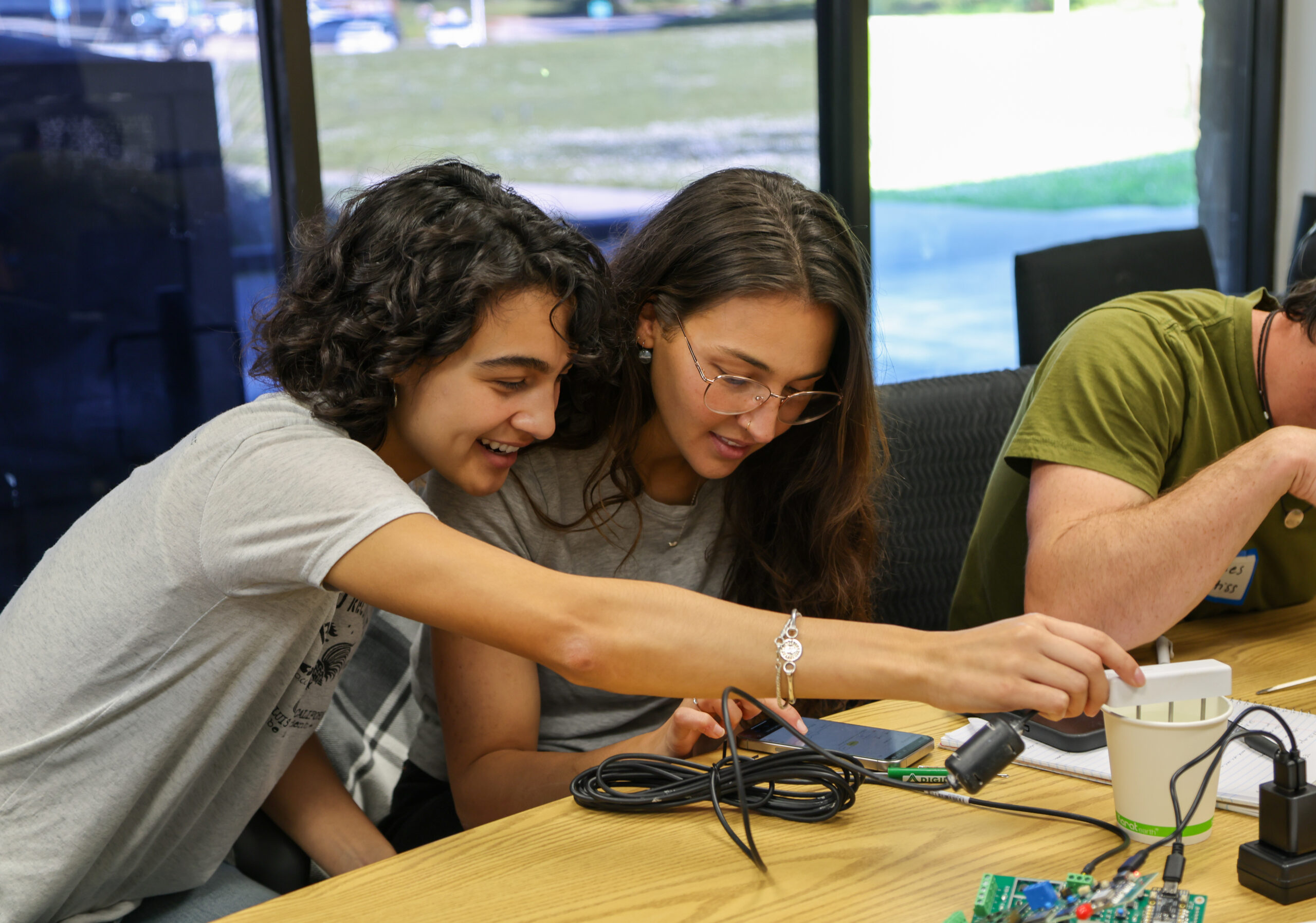 Two women lean over irrigation sensor technology