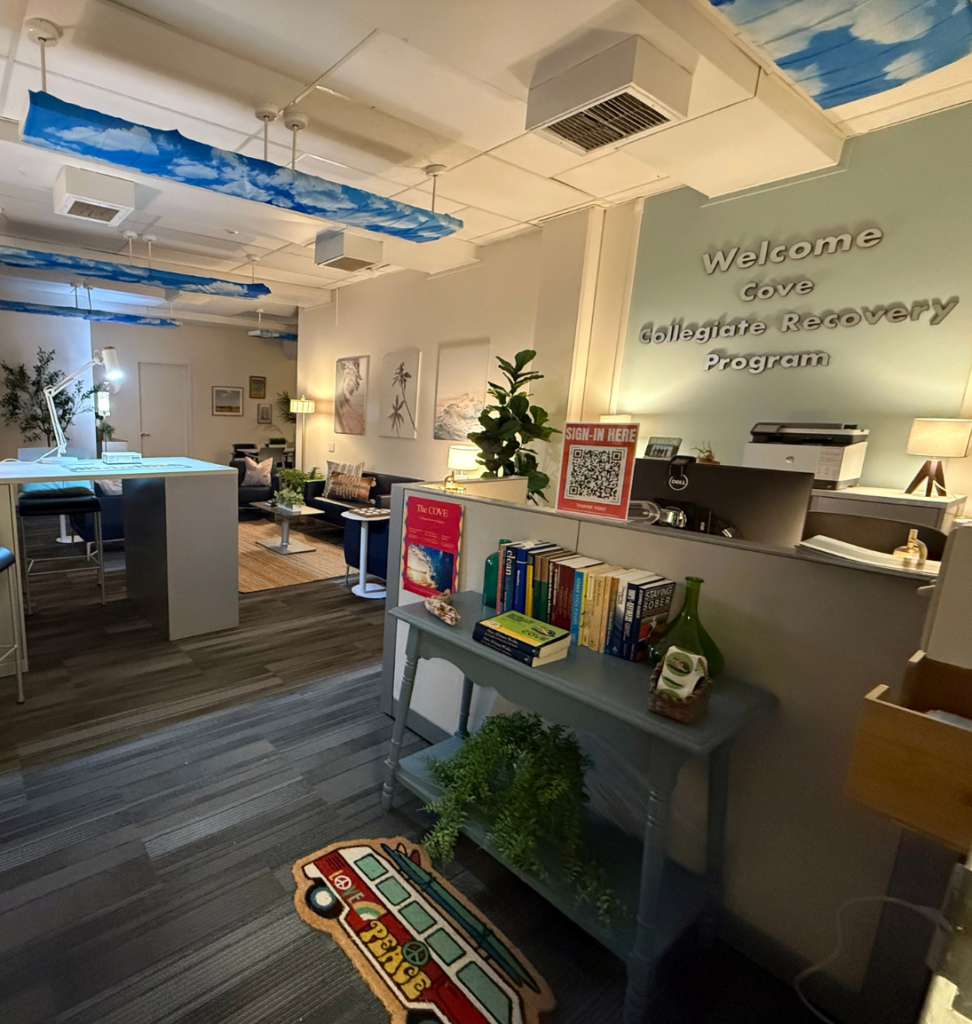 Cove entry space; includes welcome sign, bookshelf with books, and calm aesthetic.