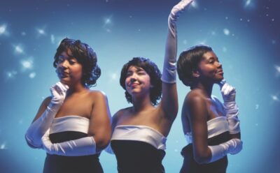 Three women dressed in 50s-style dresses