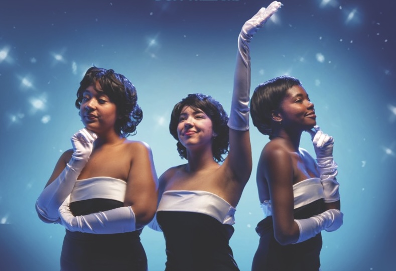 Three women dressed in 50s-style dresses