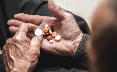 Assorted tablets in hands of elderly man