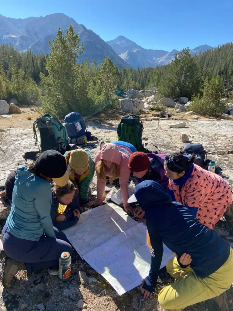 Adventure Rec students reading a map while backpacking