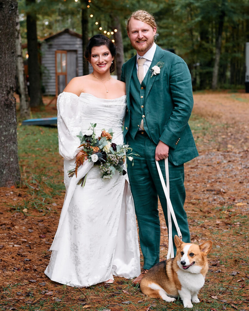 Joey and Brie pose for a photo at their wedding alongside their corgi. 
