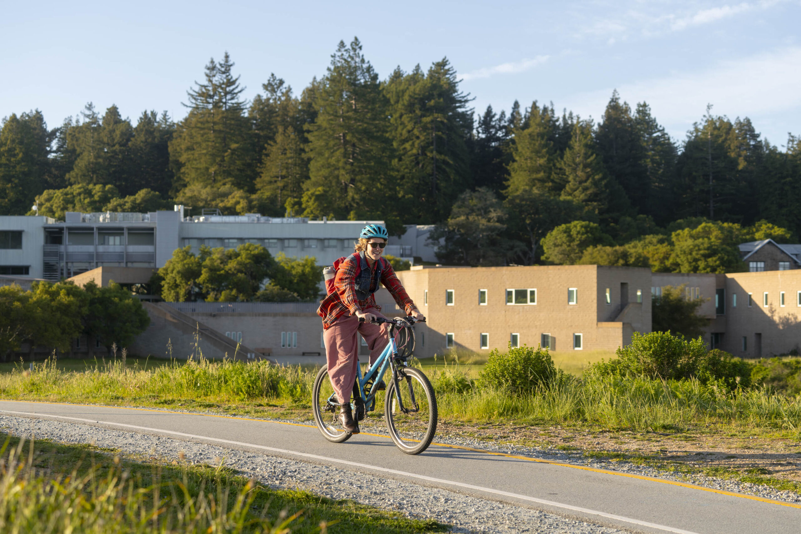 Person riding a bicycle with a helmet on campus