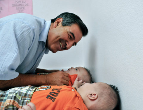 Dr. Ramon Resa leans over infant twins.