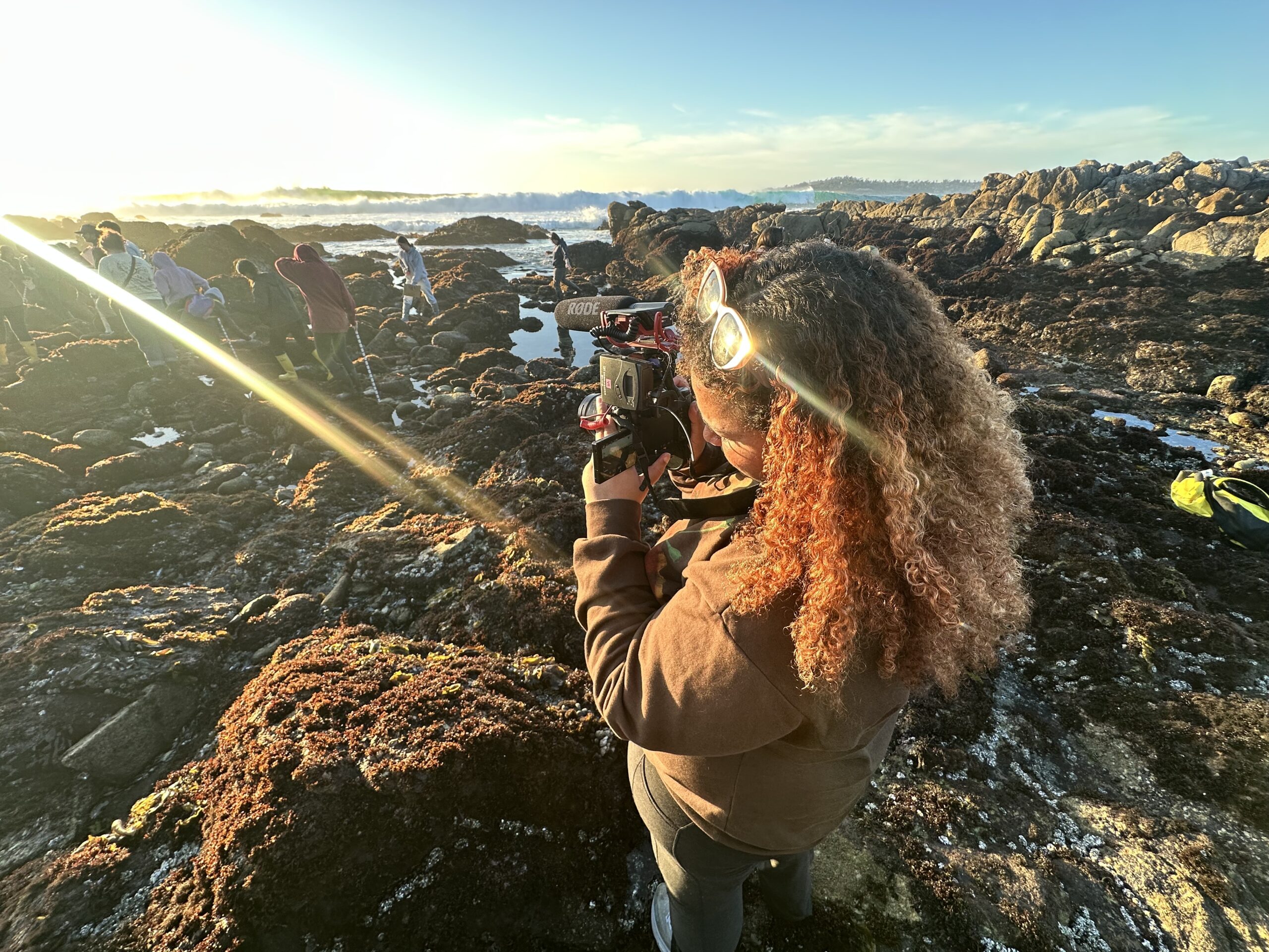 Student taking a photo at the ocean