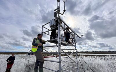 Field researchers attending to monitoring tower in the water