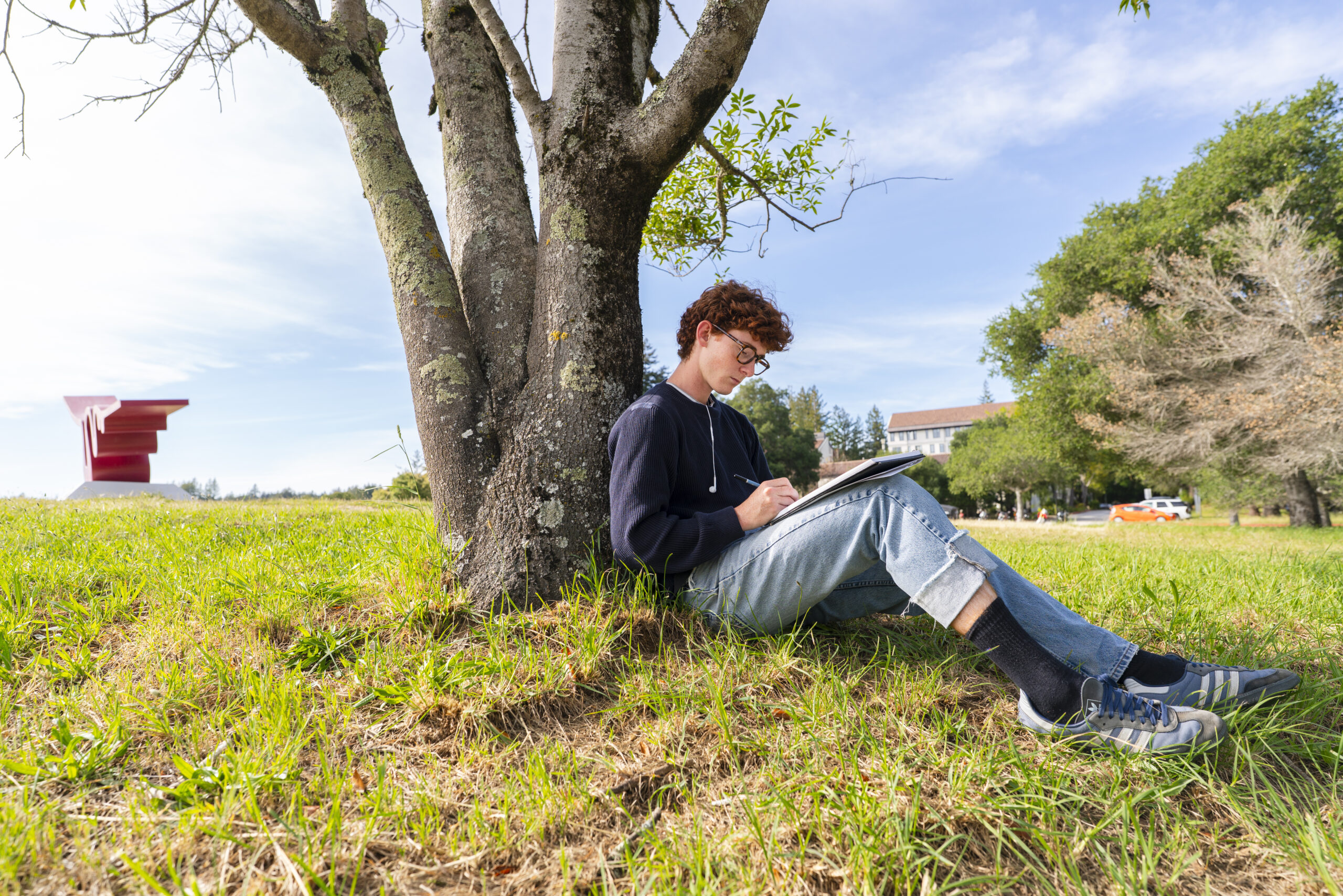 Undergrad, Theo Hayden Pink drawing under a tree near the Porter Squiggle.