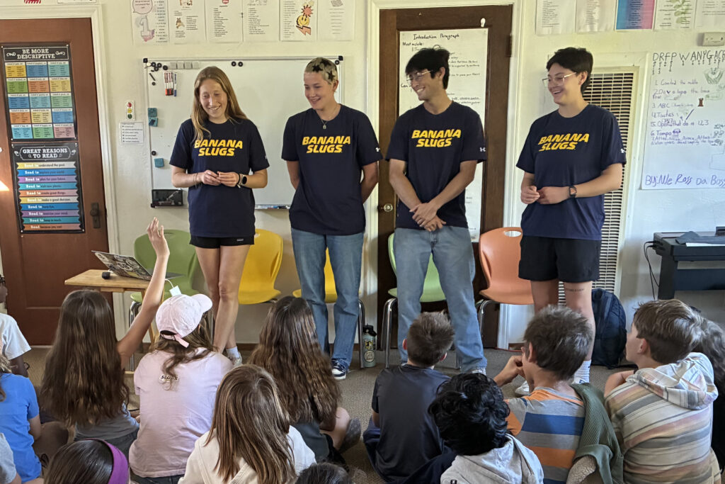 Four UC Santa Cruz students standing up in a classroom