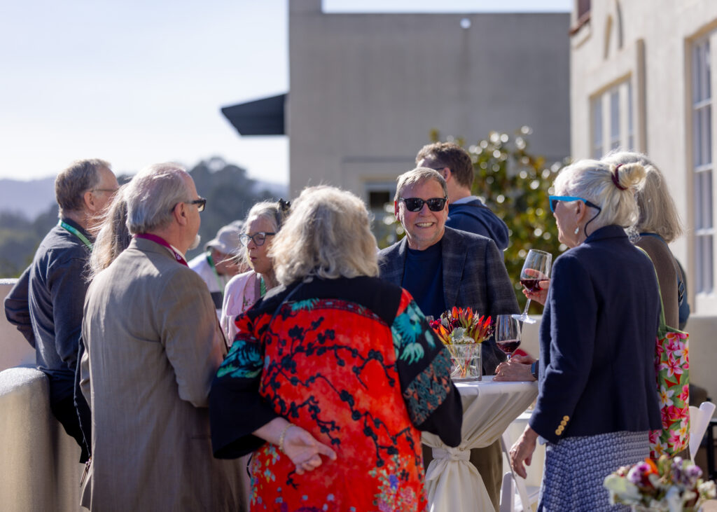 Alumni chatting on the balcony of the chaminade holding drinks.