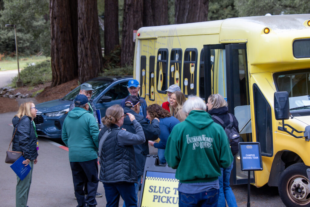 Alumni and staff share a laugh at pick-up point of campus driving tours. 