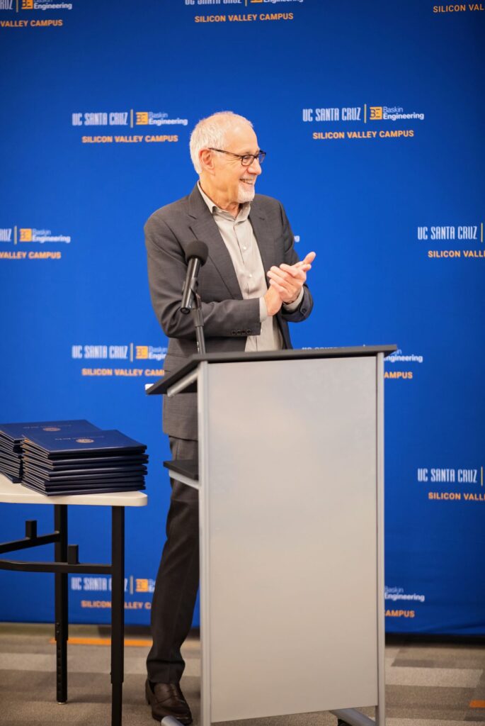Alexander Wolf applauds while standing at a podium