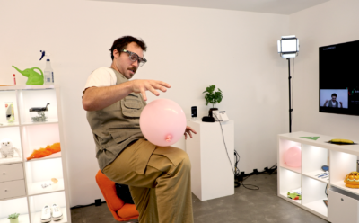 A man bounces a pink balloon off of his knee