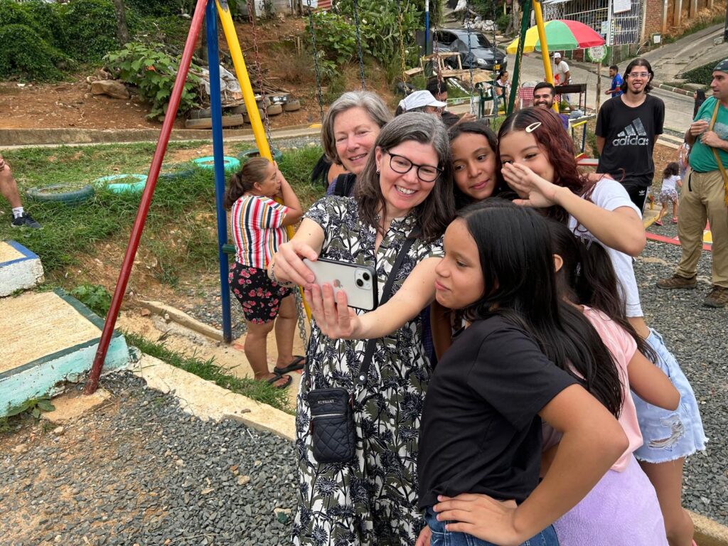 Shannon Lawder takes a selfie with Children on a playground in Colombia.