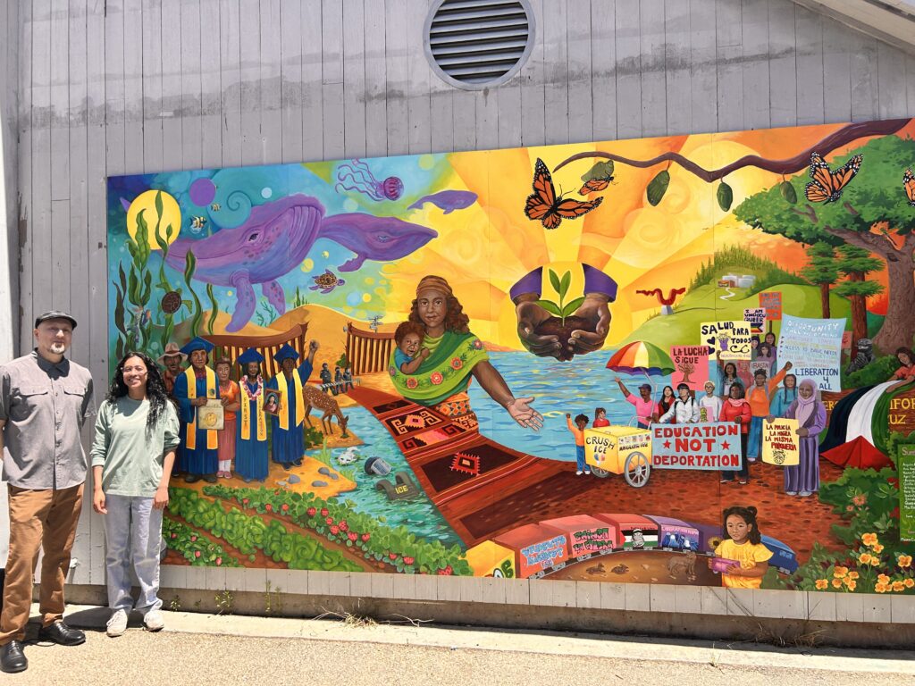 Andrea in front of a mural on UCSC campus