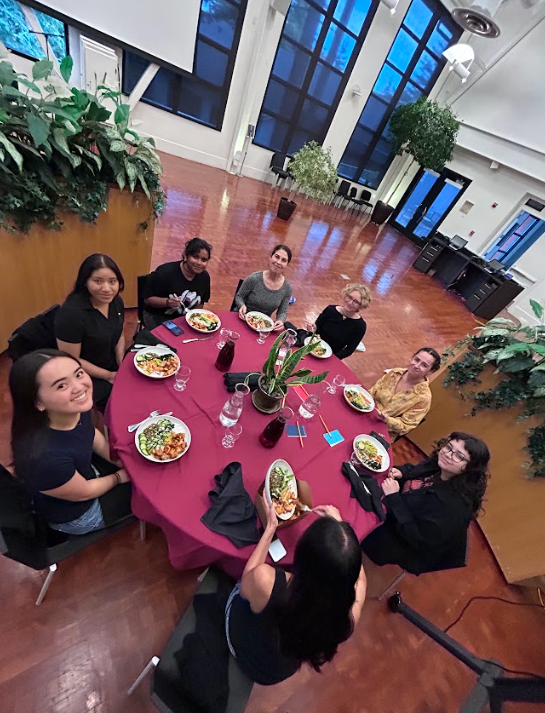 Students from PSYC 178 gather around a circular dinner table with maroon tablecloth, enjoying healthy plated meals in the University Center Bistro.