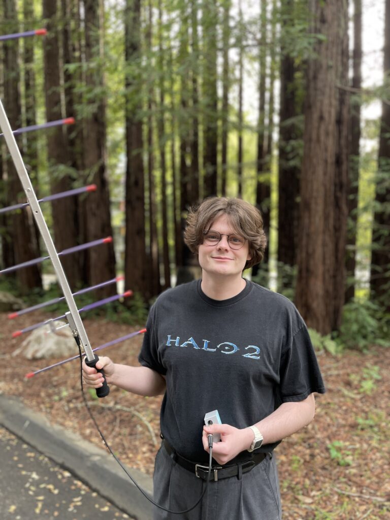 David Uniack holds a satellite in the redwoods