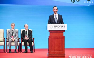 Edgar Shaghoulian standing on stage in Beijing, smiling behind a lectern