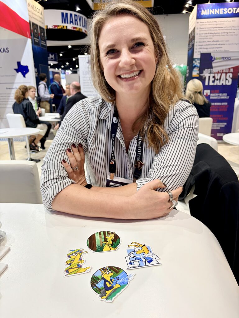 UC Santa Cruz alumna at convention booth with banana slug stickers on the table