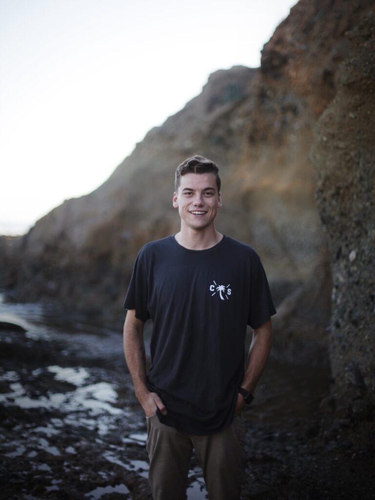 Portrait of Tim Vorenkamp standing in front of coastal rocks