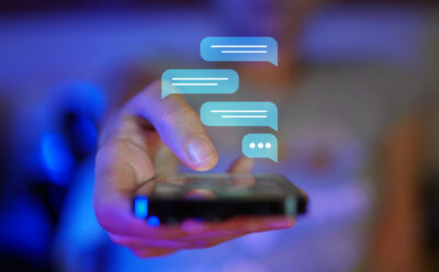 Hand showing a mobile phone towards camera viewpoint, digital overlay of messaging screen