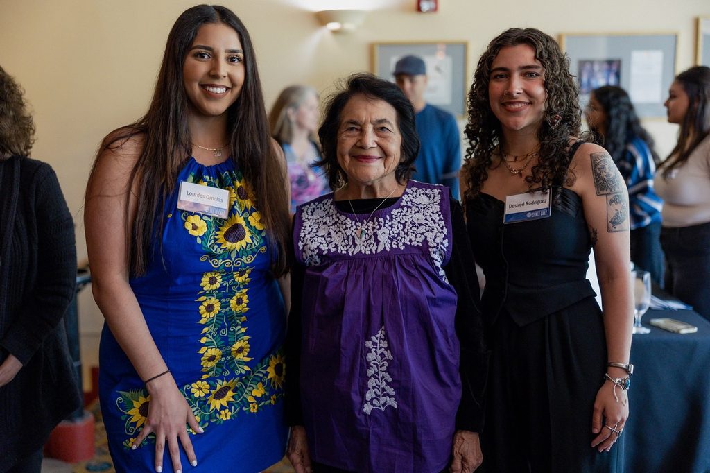 Dolores Huerta stands between two UC Santa Cruz students